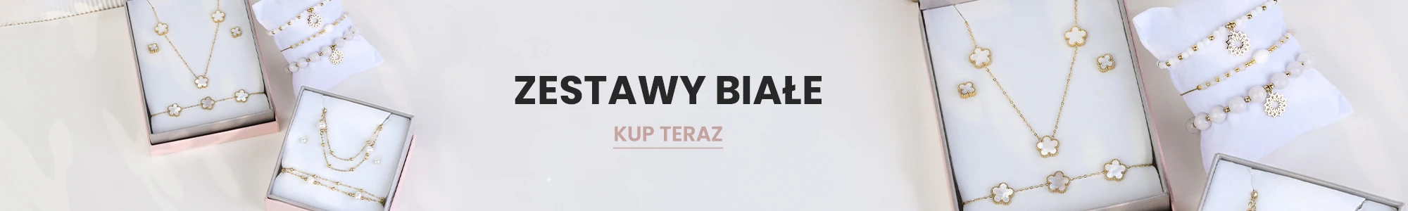 Zestawy białej biżuterii w ozdobnych pudełkach - naszyjniki, kolczyki i bransoletki z białymi i złotymi elementami. Napis: Zestawy białe. Przycisk: Kup teraz