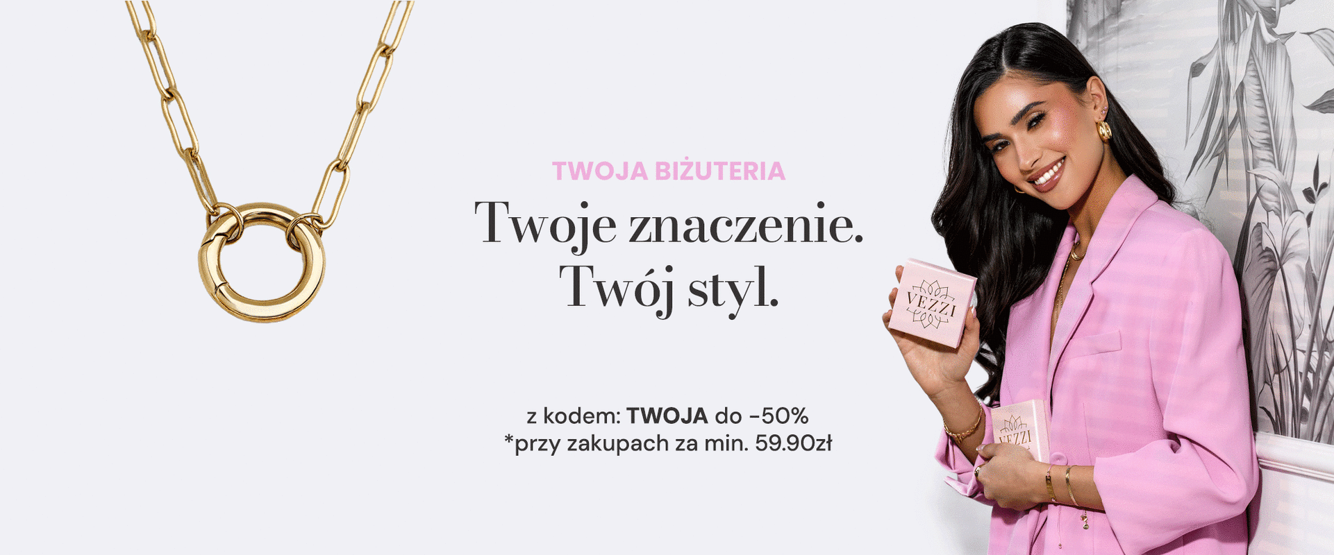 Personalizowany naszyjnik z wymiennymi zawieszkami i elementem do grawerowania oraz modelka w różowej marynarce prezentująca pudełko z biżuterią.